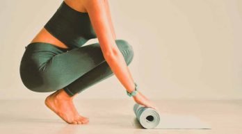young-woman-rolling-yoga-mat-at-home-2023-11-27-05-12-20-utc-scaled2